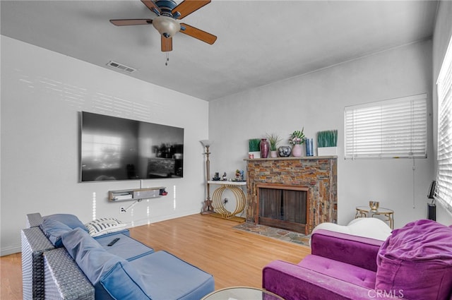 living room with a fireplace, ceiling fan, and hardwood / wood-style flooring