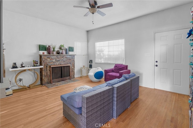 living room with ceiling fan, a fireplace, and hardwood / wood-style floors