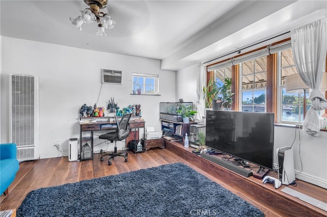 home office with ceiling fan, hardwood / wood-style flooring, and a wall mounted AC