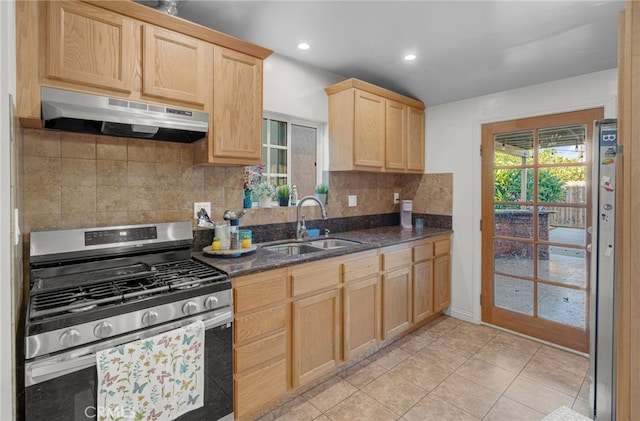 kitchen featuring light tile patterned flooring, sink, stainless steel gas stove, light brown cabinets, and dark stone countertops