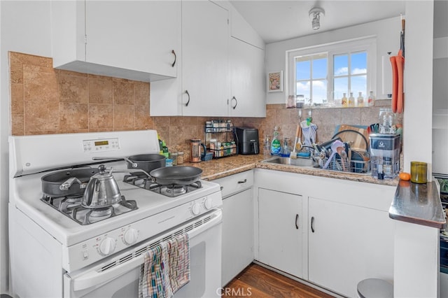 kitchen with white cabinets, backsplash, white gas range, and dark wood-type flooring