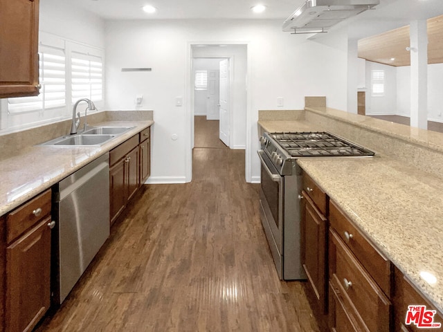 kitchen with dark hardwood / wood-style floors, light stone countertops, sink, and appliances with stainless steel finishes