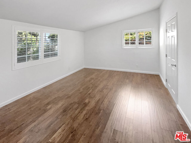 unfurnished room with hardwood / wood-style flooring, plenty of natural light, and lofted ceiling