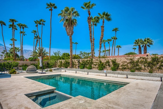 view of swimming pool featuring a mountain view, an in ground hot tub, and a patio area