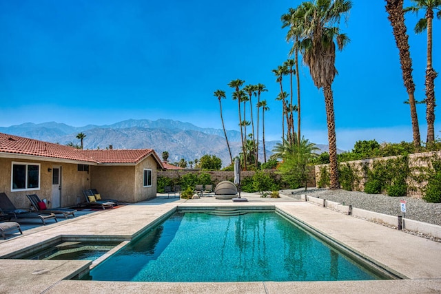 view of swimming pool featuring a mountain view, an in ground hot tub, and a patio