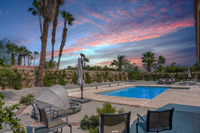 pool at dusk with a patio