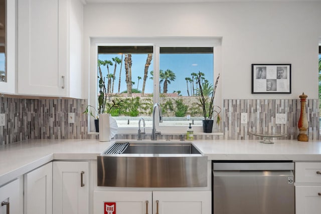 kitchen featuring decorative backsplash, dishwasher, sink, and white cabinets