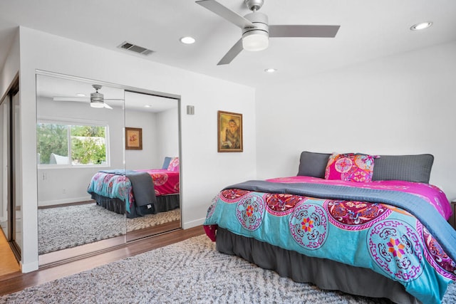 bedroom with a closet, hardwood / wood-style flooring, and ceiling fan