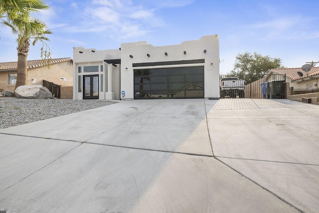 pueblo-style house featuring a garage and french doors