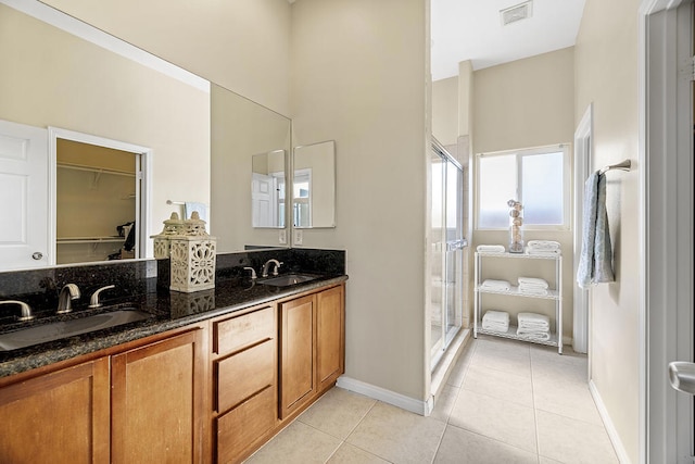 bathroom featuring walk in shower, vanity, and tile patterned flooring