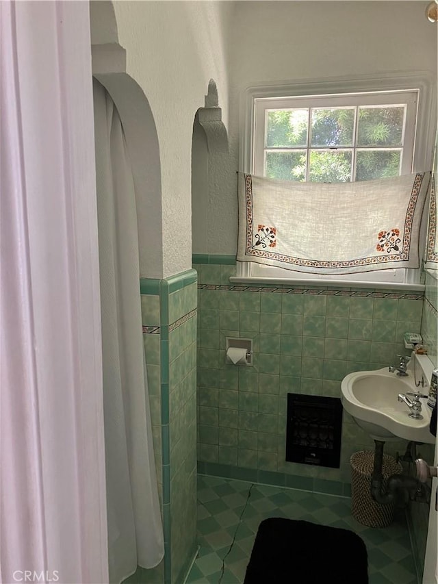 bathroom featuring tile patterned floors, sink, and tile walls