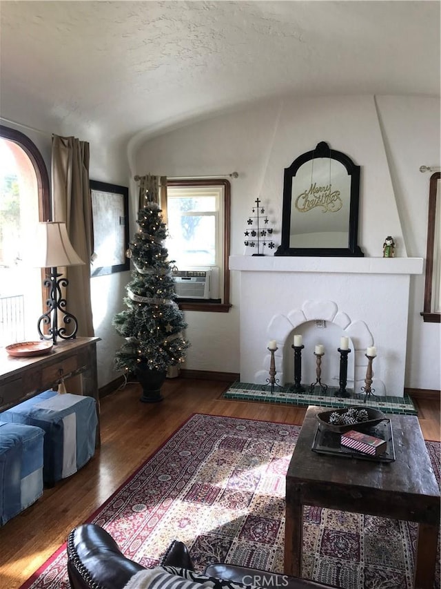 living room with dark hardwood / wood-style flooring, cooling unit, and vaulted ceiling