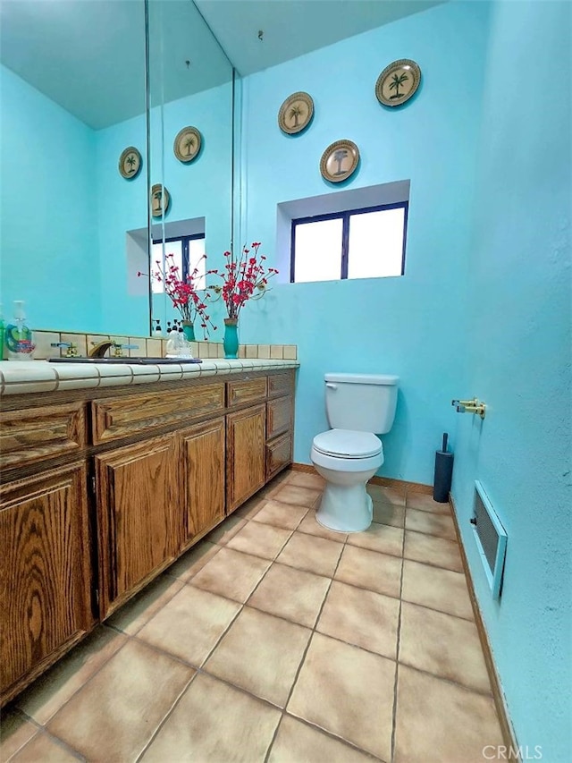 bathroom featuring vanity, toilet, and tile patterned flooring