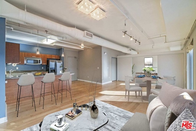 living room featuring light wood-type flooring and sink