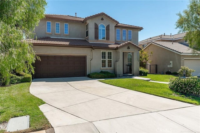 mediterranean / spanish-style home with a garage and a front lawn