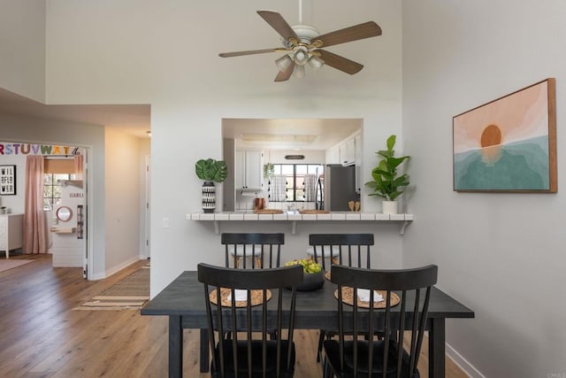 dining area with hardwood / wood-style floors and ceiling fan