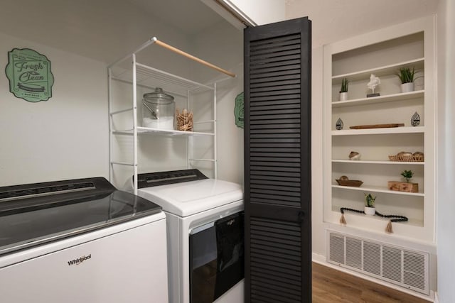 laundry room with washer and clothes dryer and dark wood-type flooring