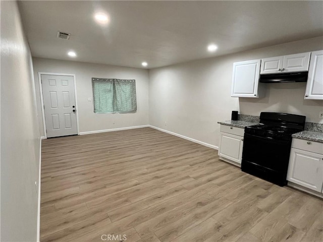 kitchen featuring light hardwood / wood-style floors, black stove, and white cabinetry