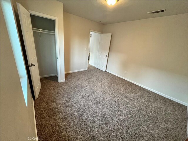 unfurnished bedroom featuring carpet and a closet