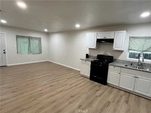 kitchen featuring black stove, light wood-type flooring, white cabinetry, and sink