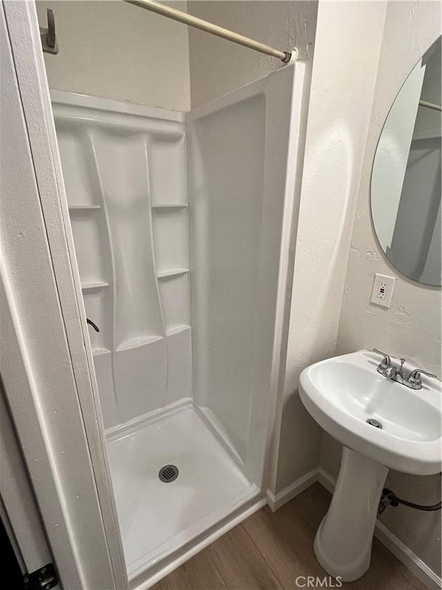 bathroom featuring a shower and hardwood / wood-style flooring