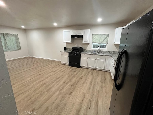 kitchen featuring black gas range, white cabinetry, sink, stainless steel refrigerator with ice dispenser, and light hardwood / wood-style floors