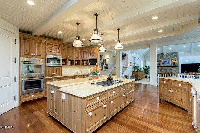 kitchen with hanging light fixtures, a kitchen island, beamed ceiling, stainless steel appliances, and dark hardwood / wood-style floors