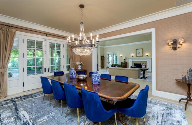 dining area featuring french doors, an inviting chandelier, and ornamental molding