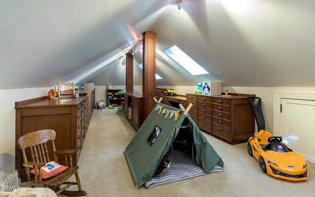 interior space with light carpet and vaulted ceiling with skylight