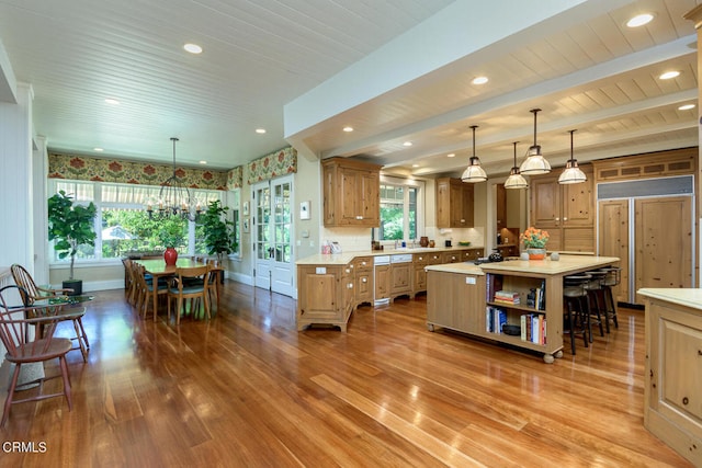 kitchen with paneled built in fridge, hardwood / wood-style floors, a healthy amount of sunlight, and a kitchen island