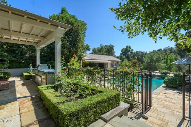 view of patio / terrace featuring exterior kitchen and a fenced in pool