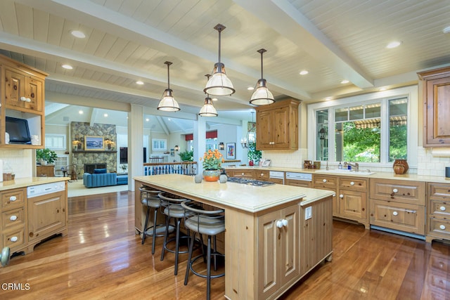 kitchen featuring a kitchen island, a breakfast bar area, decorative light fixtures, vaulted ceiling with beams, and dark hardwood / wood-style floors