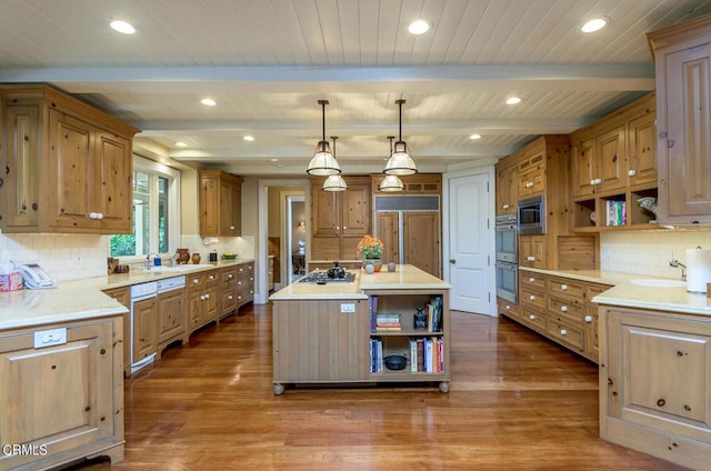 kitchen with appliances with stainless steel finishes, beamed ceiling, pendant lighting, and a center island