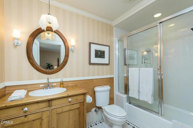 full bathroom with enclosed tub / shower combo, vanity, crown molding, and toilet