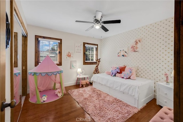 bedroom featuring dark wood-type flooring, a closet, and ceiling fan