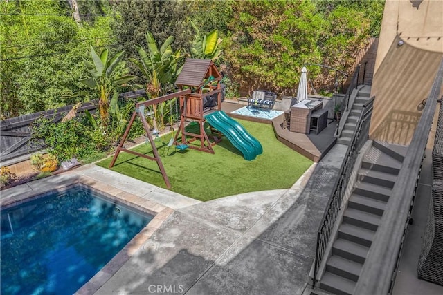 view of playground featuring a patio and a yard