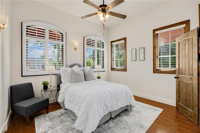 bedroom with ceiling fan and dark hardwood / wood-style flooring