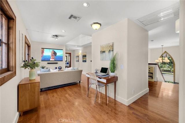 bathroom with hardwood / wood-style flooring and a chandelier