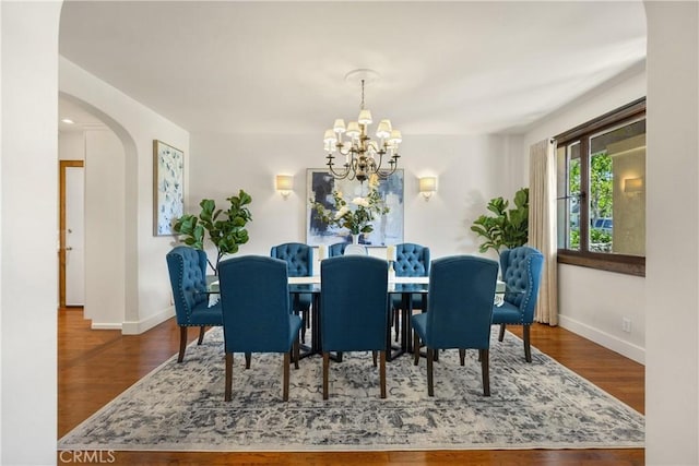 dining space featuring hardwood / wood-style flooring and a chandelier