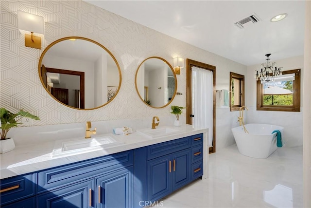 bathroom with a bathing tub, tile walls, a notable chandelier, and vanity