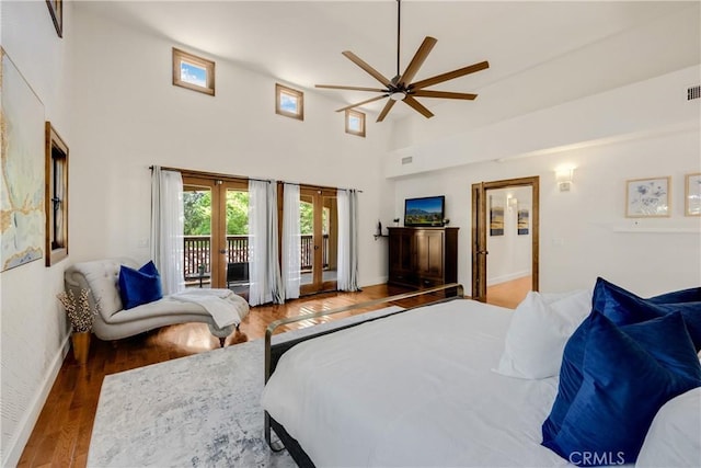 bedroom featuring ceiling fan, a high ceiling, access to exterior, and hardwood / wood-style flooring