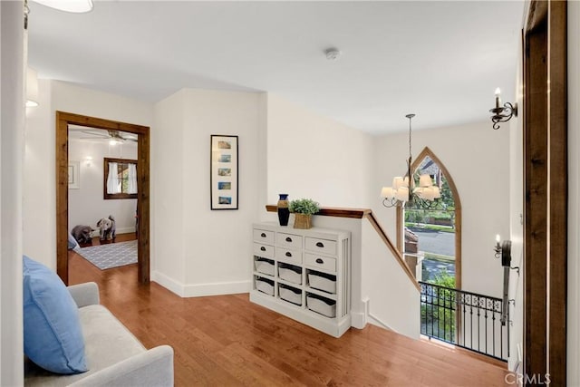 living area featuring hardwood / wood-style flooring and ceiling fan with notable chandelier