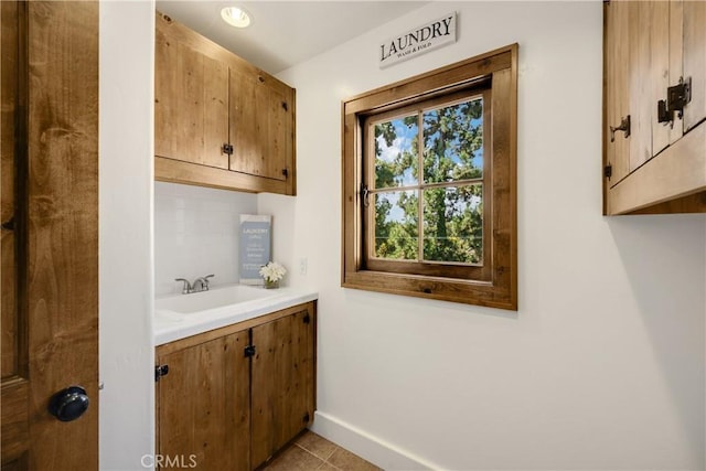 bathroom with backsplash, tile patterned flooring, and vanity