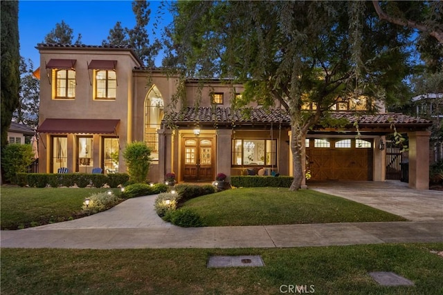 mediterranean / spanish house featuring a front lawn, a carport, and french doors