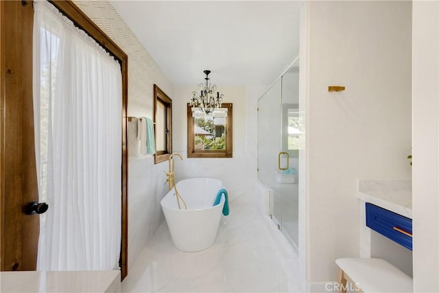 bathroom featuring plus walk in shower, a chandelier, and vanity