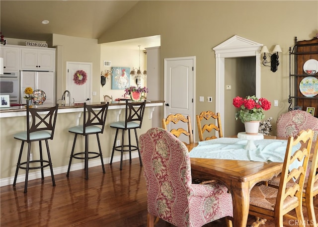 dining area with lofted ceiling and dark hardwood / wood-style flooring