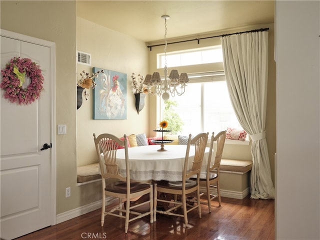 dining room with an inviting chandelier and dark wood-type flooring