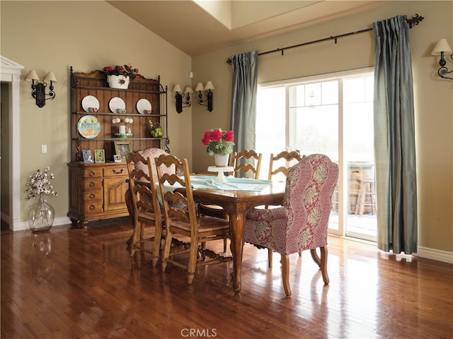 dining area featuring lofted ceiling and dark hardwood / wood-style floors