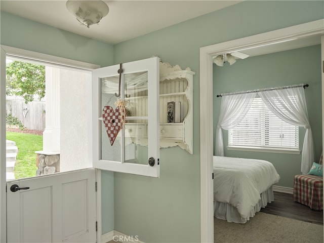 bedroom with hardwood / wood-style flooring and multiple windows