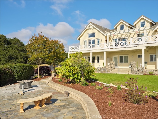 rear view of property featuring a yard and a patio area